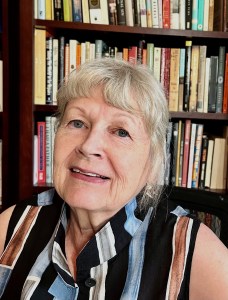 Woman in front of bookshelves.